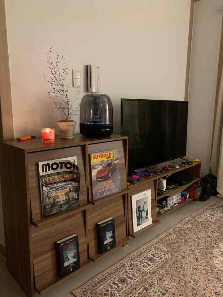Cozy living room with warm brown and beige tones, featuring wooden furniture and Persian-style rug