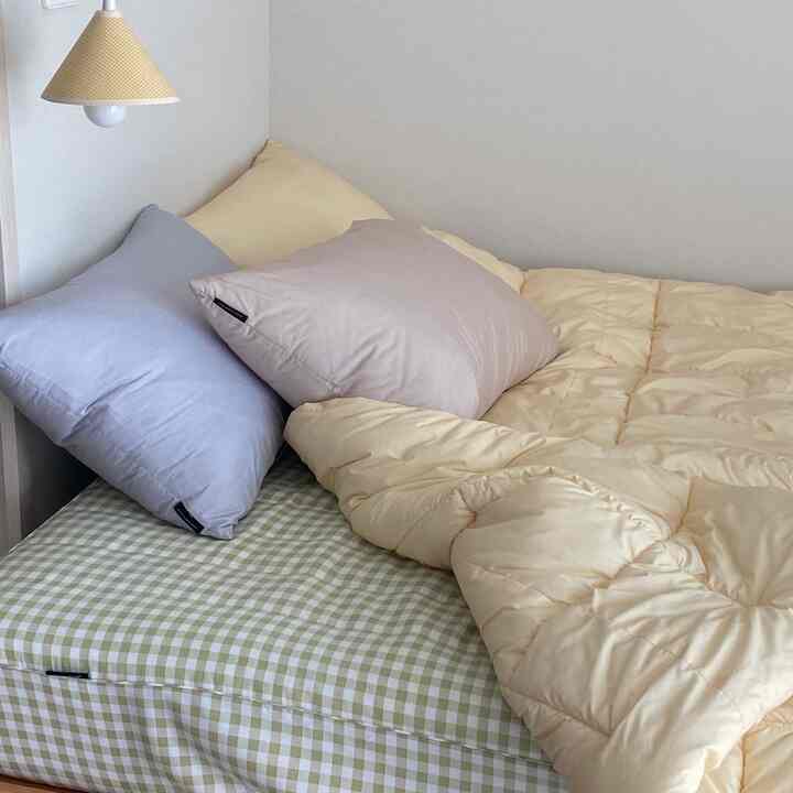 A cozy bedroom in soft beige and white tones featuring bright bedding and natural lighting creating a harmonious atmosphere