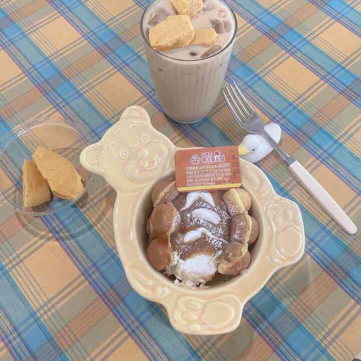 Yellow and blue plaid tablecloth on dining table featuring a bear-shaped bowl and a duck cutlery holder, creating a cozy dining scene