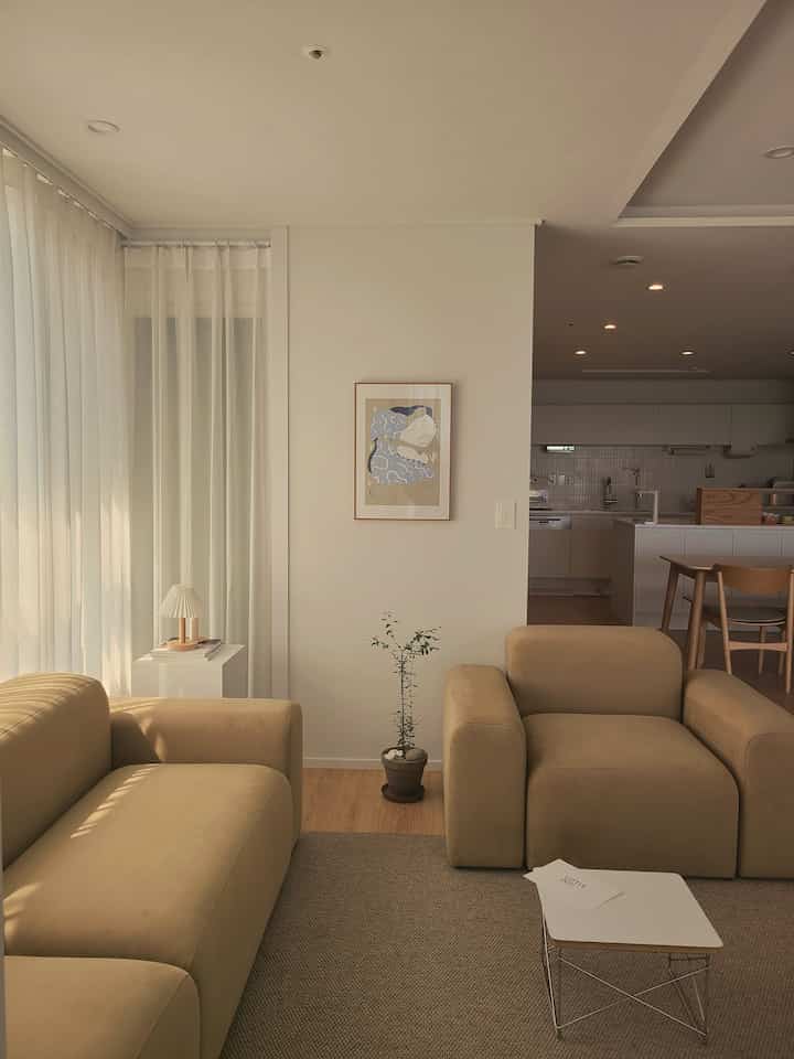 White and brown toned living room with natural modern style sofa and picture frame creating a cozy atmosphere