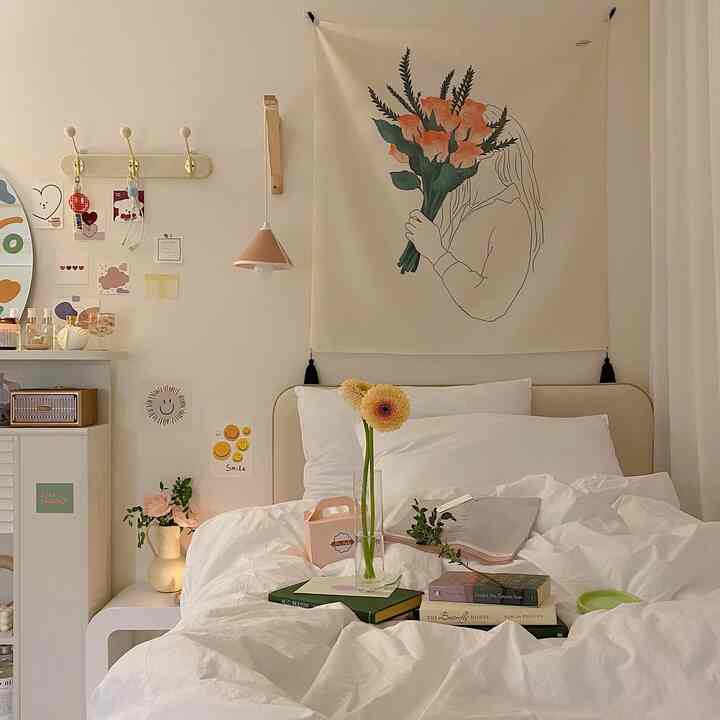 Natural-toned cozy bedroom with white high-density bedding centered, featuring a vase of flowers and soft lighting