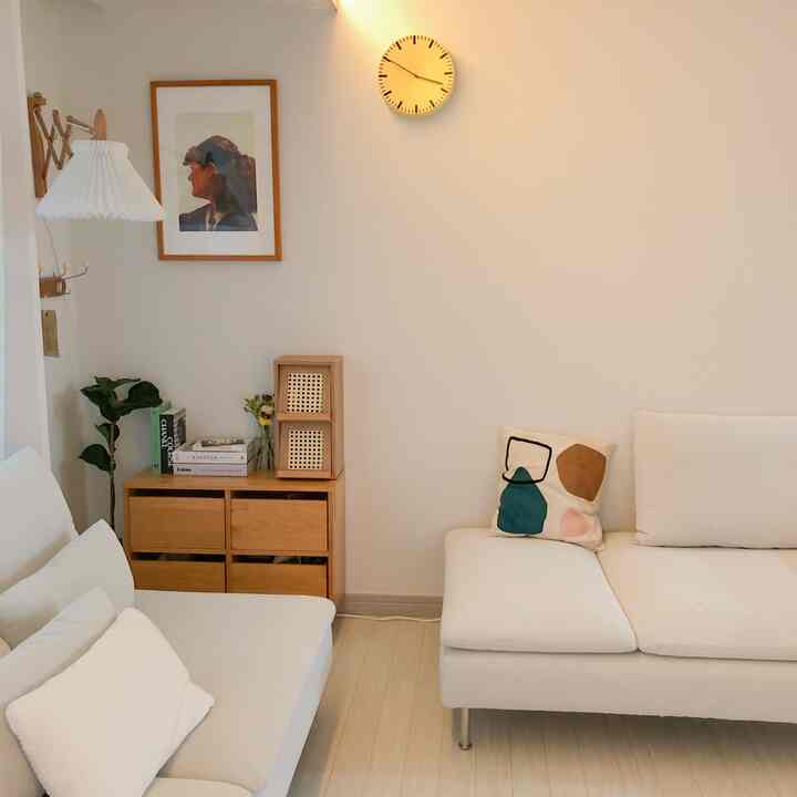 White and wood tone living room featuring IKEA sofas and natural wooden drawer, creating a simple and natural modern atmosphere