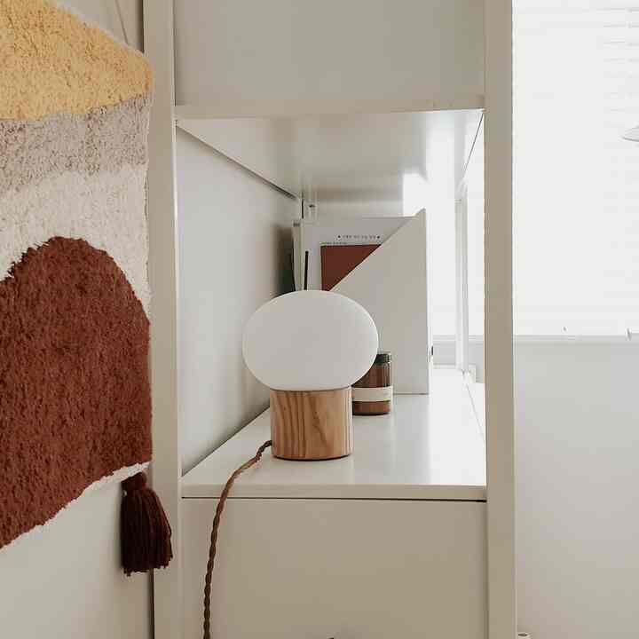 A white and natural wood-tone study featuring a minimalist setup with clean lighting and organized storage
