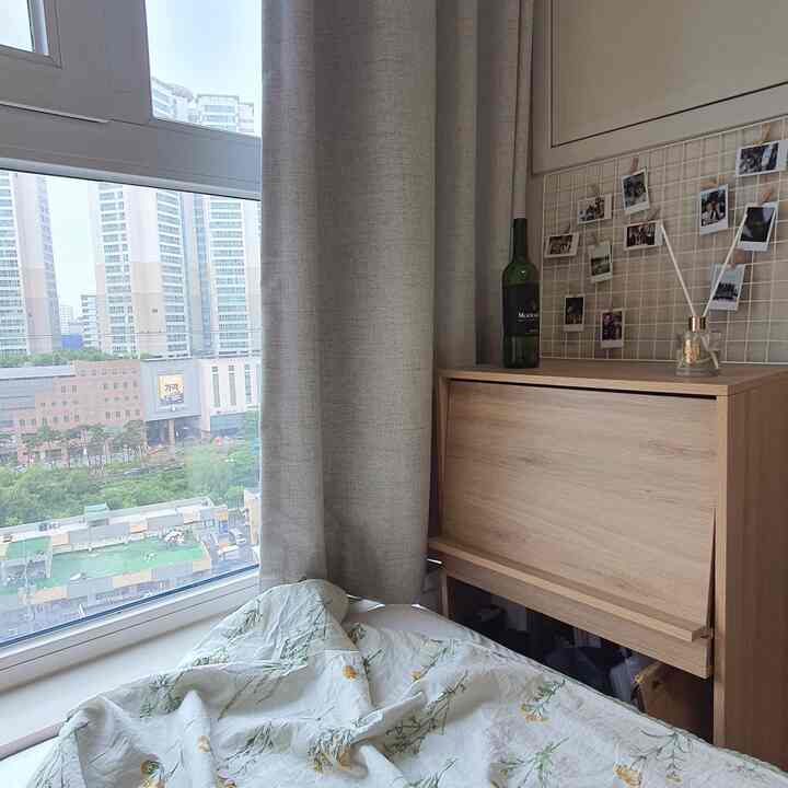 Beige-toned curtains and wooden furniture in a 6-tatami studio apartment window-side resting area