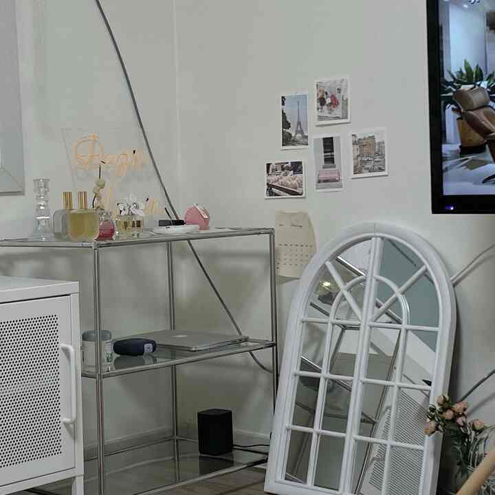 Cozy living room corner featuring white and metal modular furniture with posters on the wall
