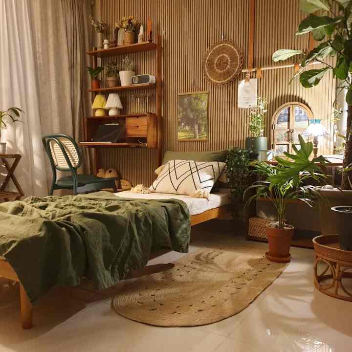 Natural toned bedroom featuring solid wood bed and desk with various plants, creating a cozy and warm atmosphere
