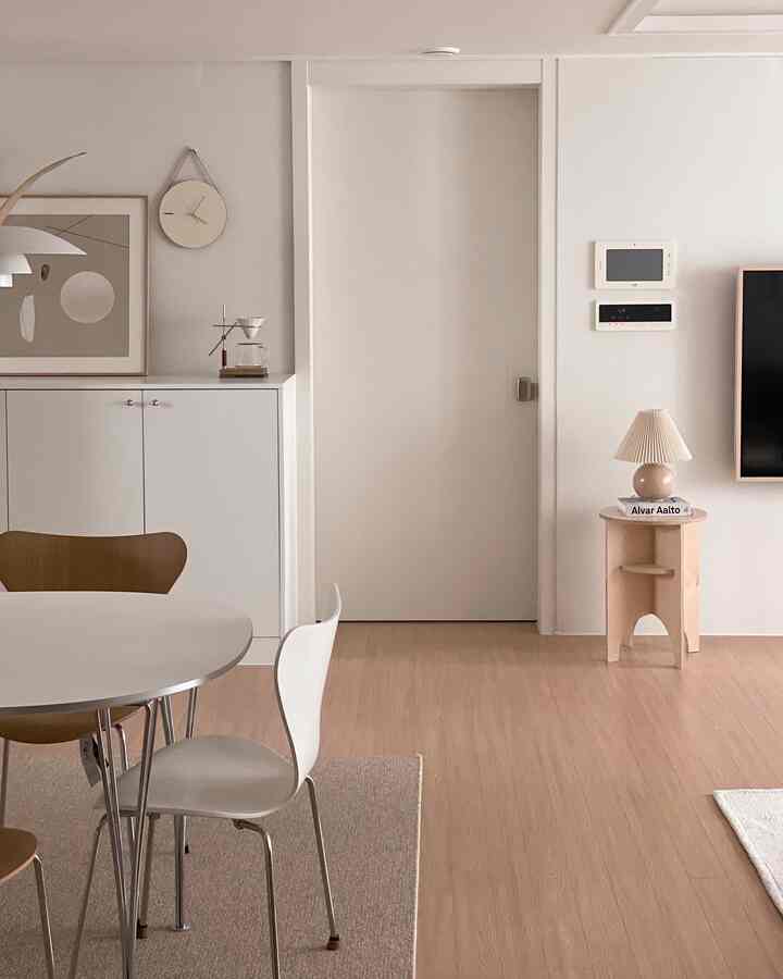 Bright beige and white toned dining room featuring simple natural dining table and chairs with a clean atmosphere