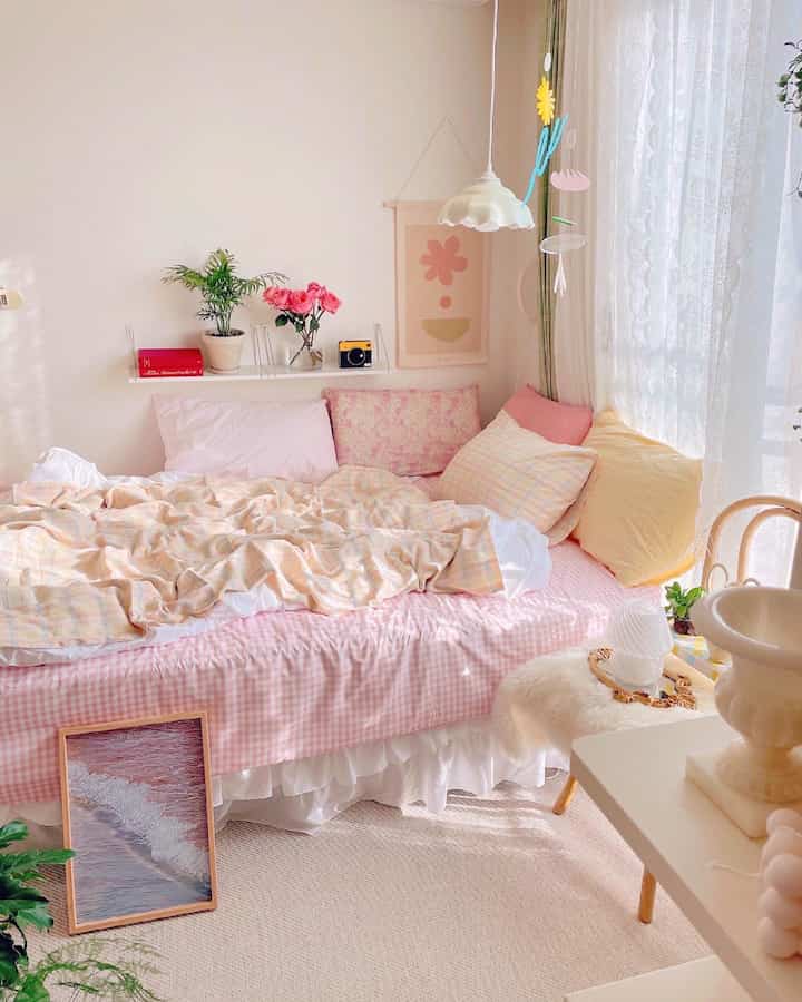 Beige and pink toned bedroom featuring cozy bedding and plants creating a warm atmosphere