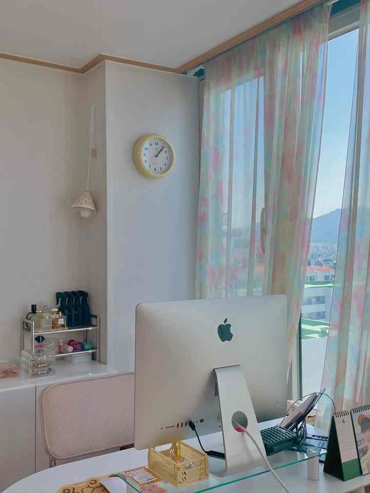 Pastel-toned curtain studio home office space featuring an iMac and desk with bright, clean workspace atmosphere