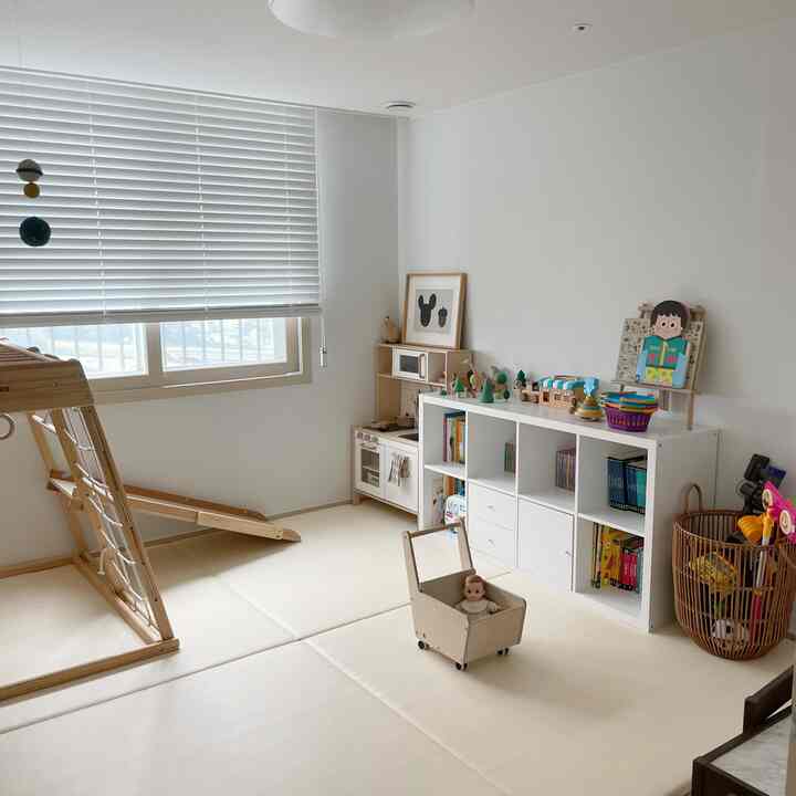 白と木目調が調和した子供部屋、玩具や本棚が整然と配置されたナチュラルモダンな雰囲気のインテリア