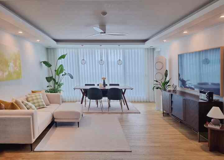A cozy mid-century modern living and dining room featuring white, beige, and wood tones in harmony