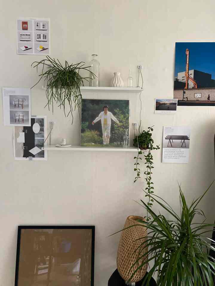 ホワイトの壁に額縁と植物が配置されたナチュラルな雰囲気のリビングの壁