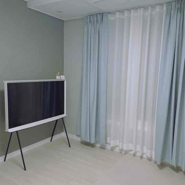 Studio living room featuring sky blue and white curtains with a modern and clean atmosphere