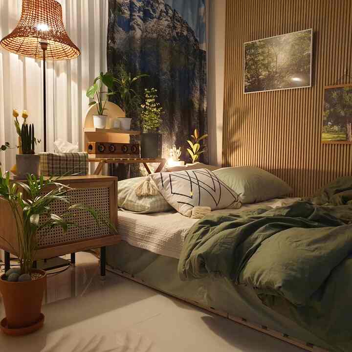 Natural wood-toned and green studio bedroom featuring rattan floor lamp and plant decor for a cozy atmosphere