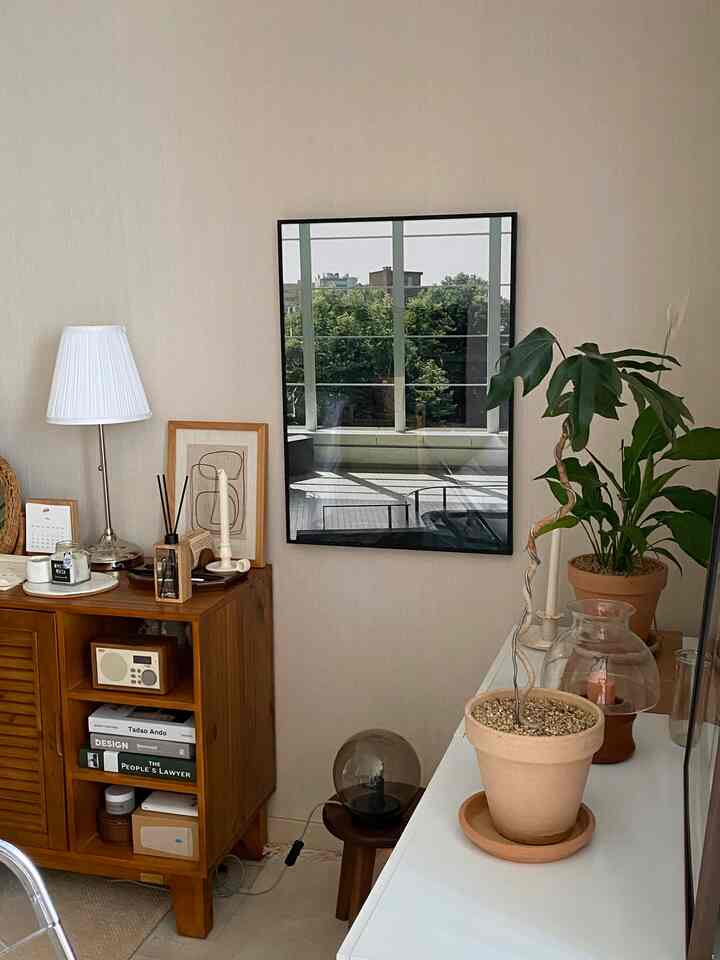 Natural and simple living room with beige walls, wood-tone furniture, and potted plants