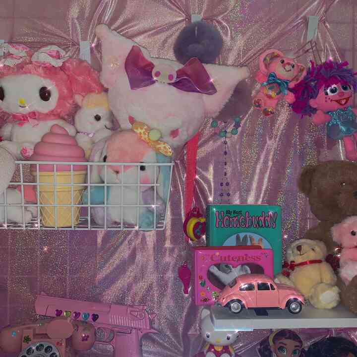 ピンクのキラキラしたカーテンとぬいぐるみが並ぶかわいらしい部屋