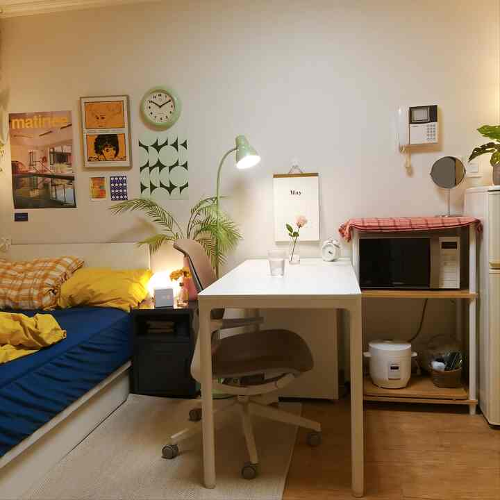 White and natural-toned single household bedroom with home office setup, clean and cozy atmosphere