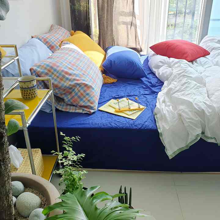White and blue toned bedroom featuring varied pillows and bedding creating a cozy atmosphere