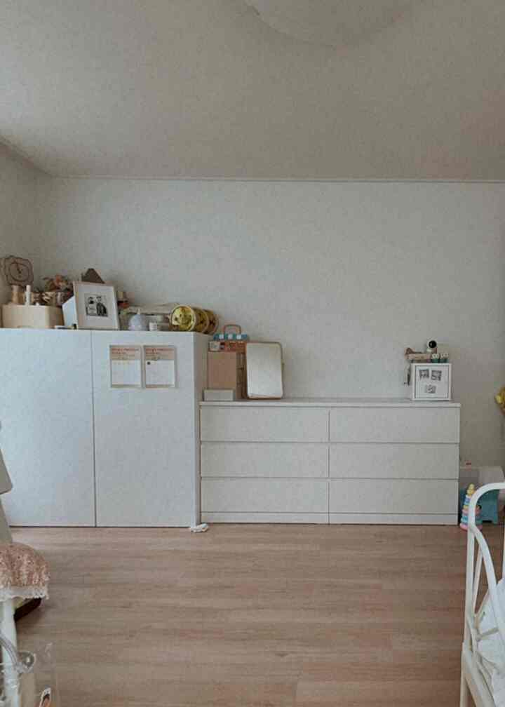 白とナチュラルカラーの子供部屋、左にワードローブ、右に6段チェストが配置されたシンプルで収納中心のインテリア