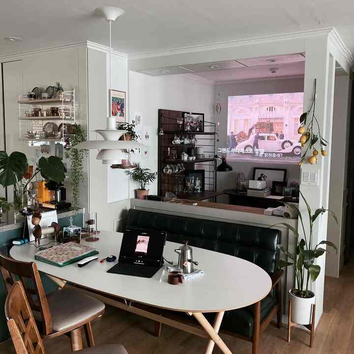 ホワイトとウッドトーンが調和するリビング兼ダイニング空間、ホームシネマ用プロジェクターとおうちカフェの要素が配置された雰囲気のあるインテリア