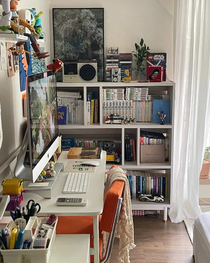 White and orange tone home office space featuring desk and bookshelf with a cozy, functional atmosphere