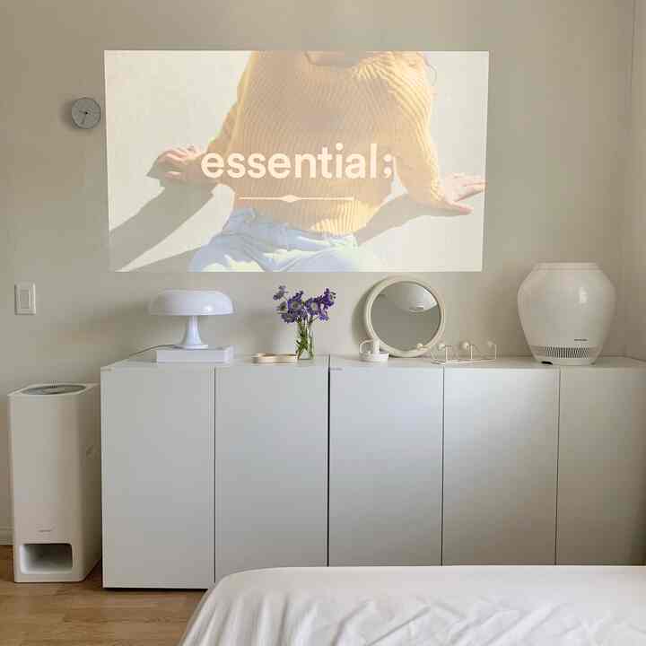 White-toned bedroom featuring white cabinets, lighting, BALMUDA air purifier, and evaporative humidifier in a clean minimalist interior