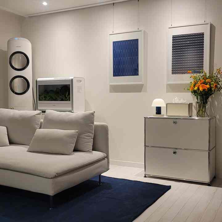 ホワイトとネイビーのトーンのモダンなリビング、ホワイトのソファとネイビーのラグ、ホワイトのキャビネットと壁のアートが調和した空間