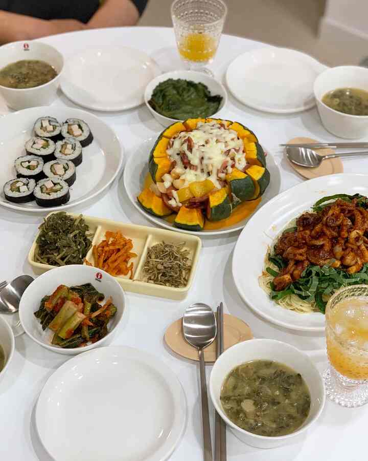 White round dining table featuring various Korean home-cooked dishes and plates in a neat home dining setting