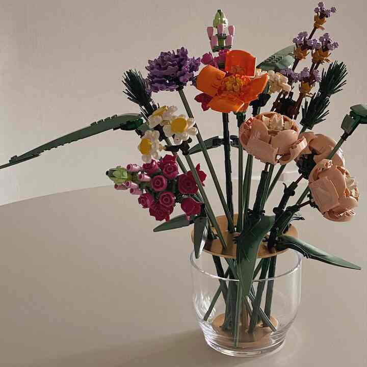 Neutral-toned table featuring transparent vase with LEGO flower bouquet as decorative interior element