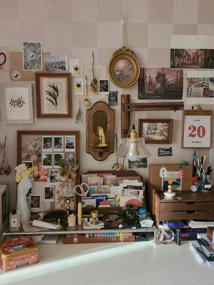 温かみのある木目調とヴィンテージ小物が並ぶホームオフィス、額縁とポスターが壁を彩る雰囲気のある空間