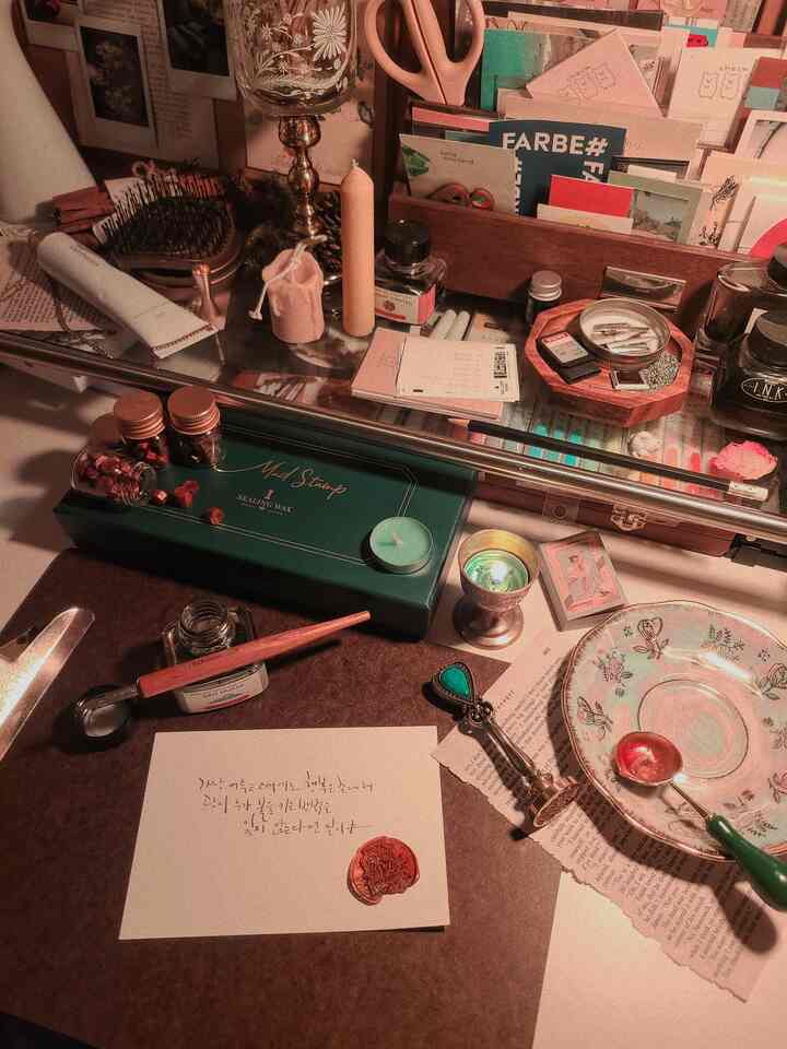Cozy study space in warm brown vintage tones featuring candles and sealing wax set on a desk with ambient lighting