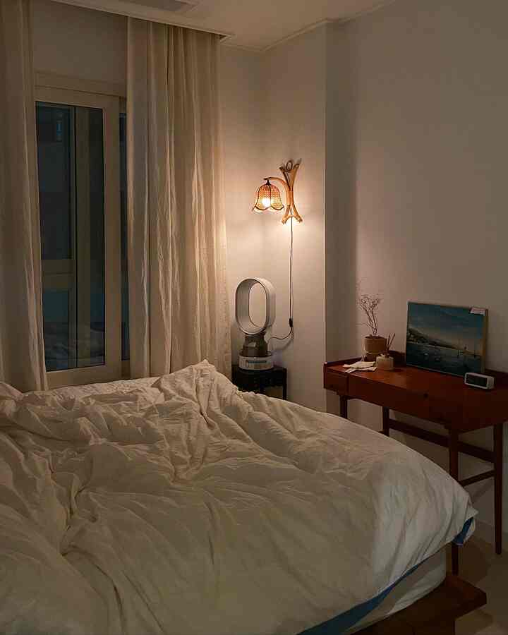 Natural beige and white-toned bedroom featuring linen curtains and wood-tone furniture with a cozy atmosphere
