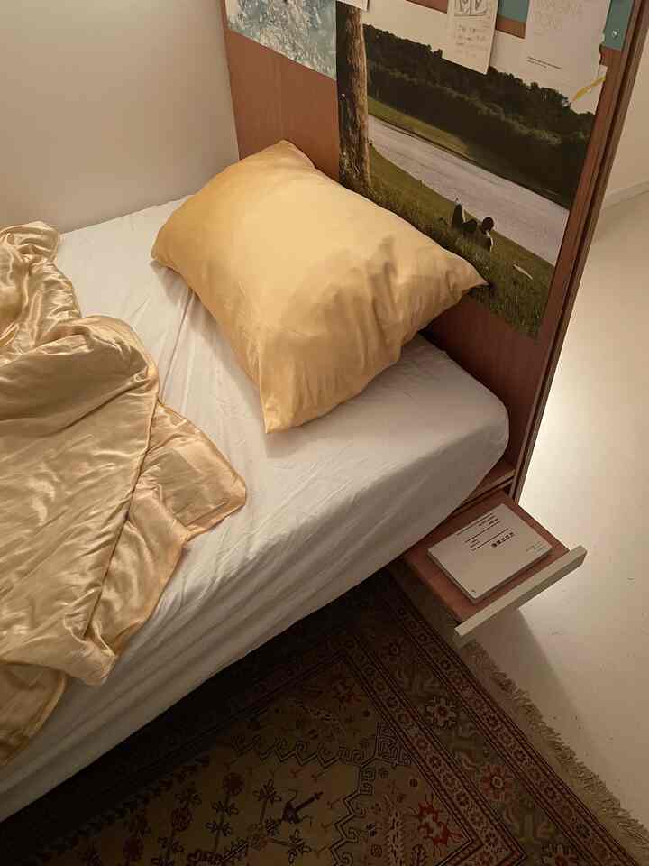 Beige-toned bedroom featuring a wooden headboard and poster creating a cozy atmosphere