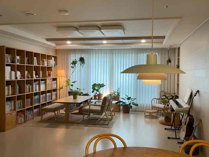 ナチュラルな木目調と植物が配置された広々としたリビング兼ダイニング、心地よく温かみのある空間