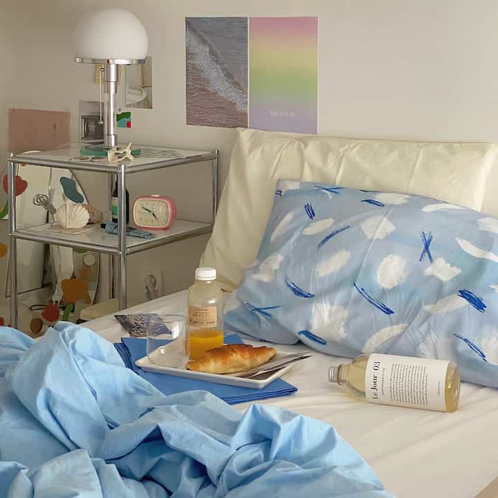 Sky blue and white toned bedroom featuring pillows and duvet cover creating a calm, refreshing atmosphere