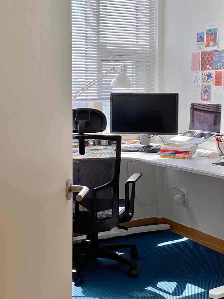 White-toned home office featuring a desk, office chair, and monitors creating a neat workspace