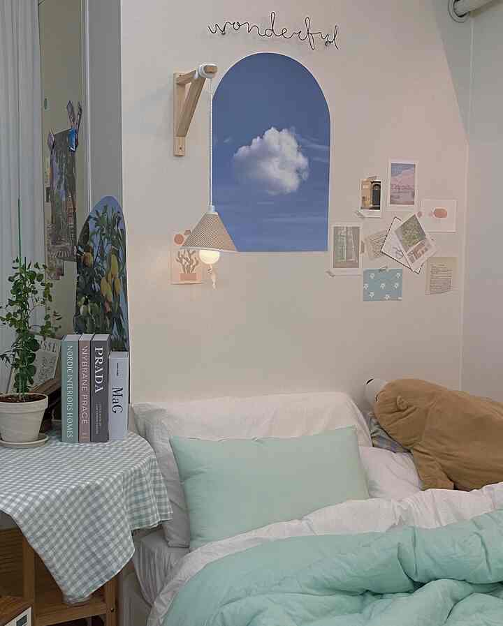 Bright and calming mint and white bedroom featuring mint bedding and light wood round table creating a cozy space