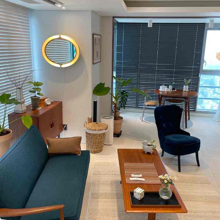 A natural-toned living room featuring wood tone vintage furniture and green plants creating a cozy atmosphere