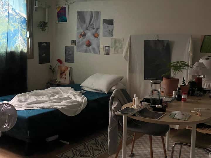 Blue and white toned studio dining room featuring bed and dining table with a natural atmosphere