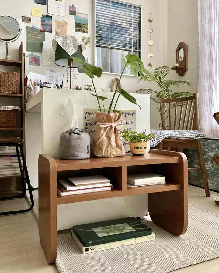 Natural-toned bedroom featuring a wooden side table and various plants arranged in a cozy setting