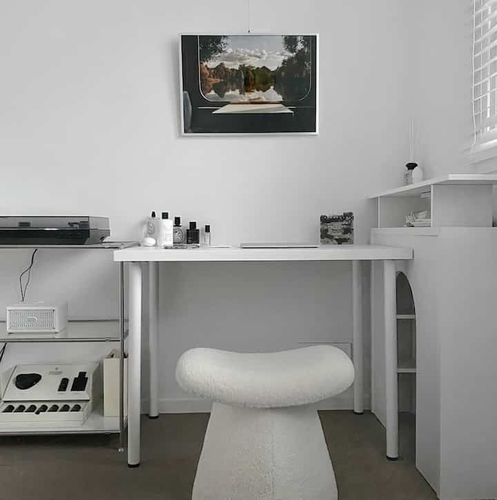 白とグレーのトーンのホームオフィス、モダンなデスクとチェアが配置されたシンプルなインテリア