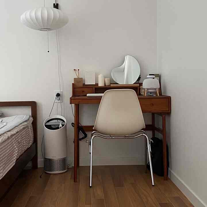 White walls and wood tone floor in a compact bedroom featuring a desk and chair with a modern atmosphere