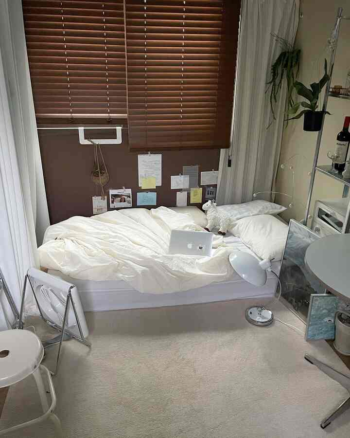 White and brown toned bedroom featuring a bed, curtains, and rug in a cozy setting