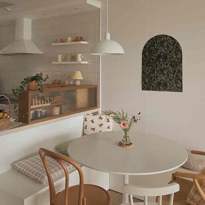 Natural-tone kitchen space featuring a round dining table with various chairs in a cozy interior