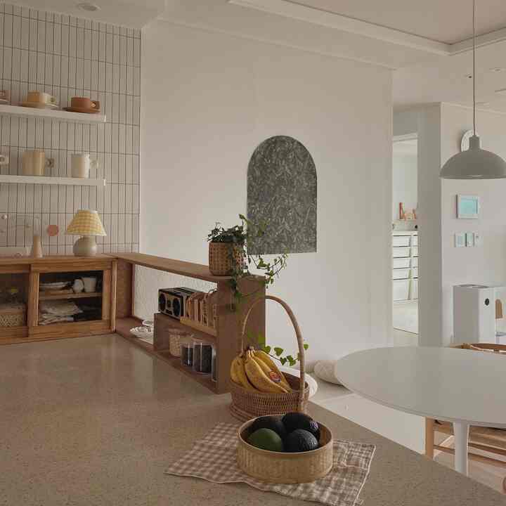 ナチュラルな木目調と白を基調としたキッチン空間、ラタンバスケットとコーヒーグッズが配置された居心地の良いおうちカフェの雰囲気