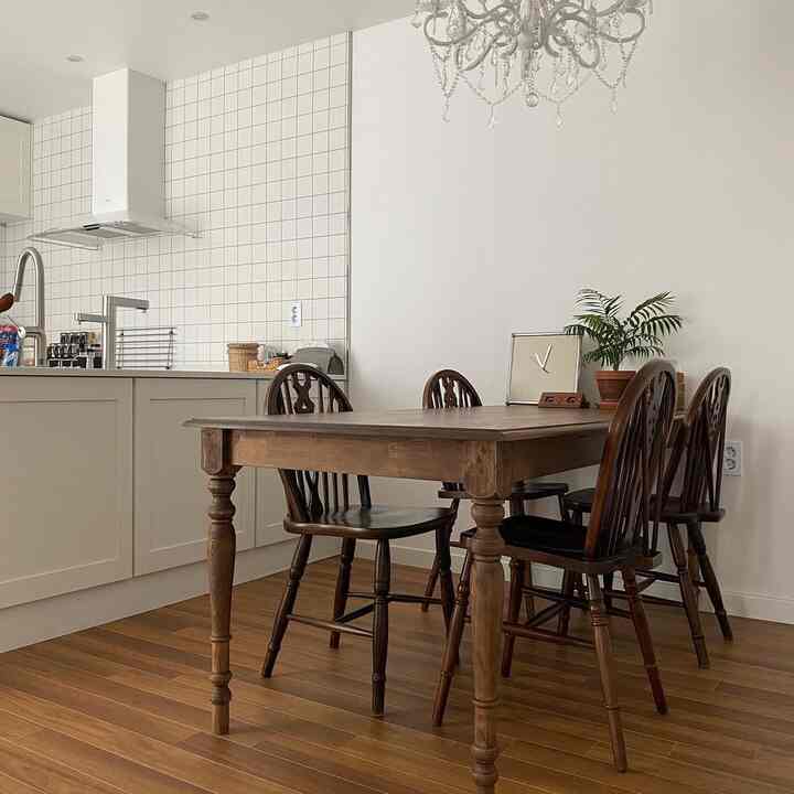 Warm brown wood tones and white blend in a kitchen featuring a vintage classic dining table set with a cozy atmosphere
