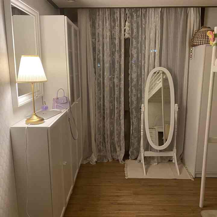 White and natural tone kids' room featuring a bunk bed, full-length mirror, and storage cabinets in a neat cozy setting