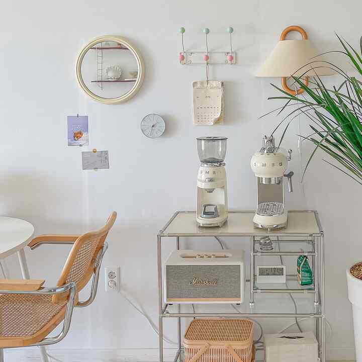 White and wood tone home cafe area featuring Smeg coffee machines and rattan armchair with cozy natural atmosphere