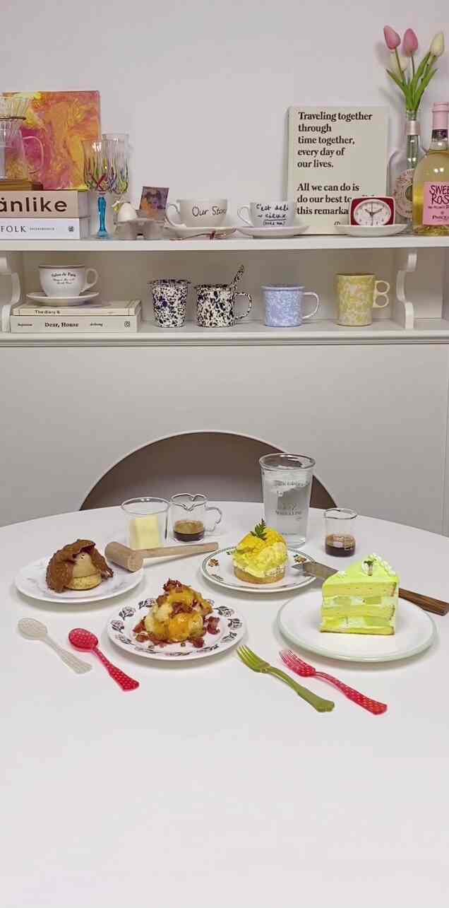 White-toned home cafe space featuring dessert plates, various cups on table and shelves creating a cozy interior
