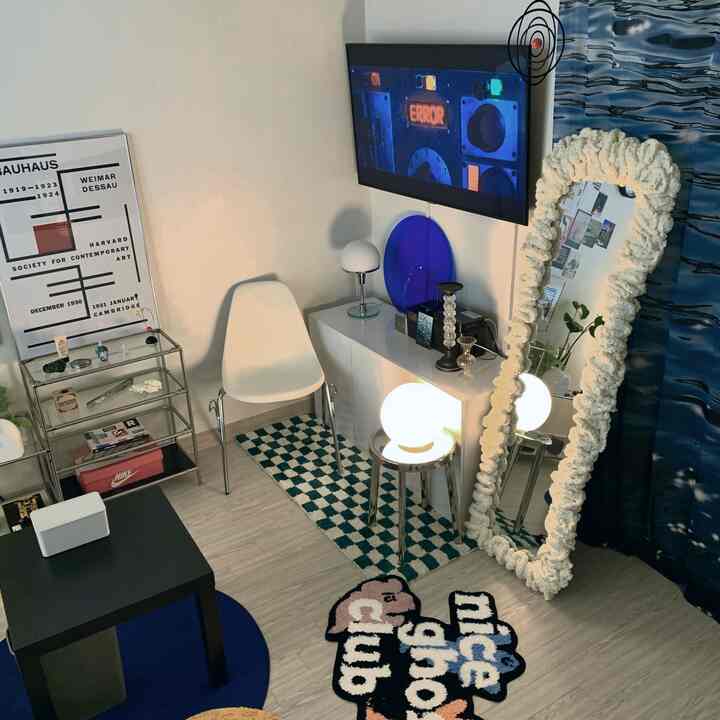 Natural color and white toned living room featuring wall-mounted TV and minimal furniture in a modern interior